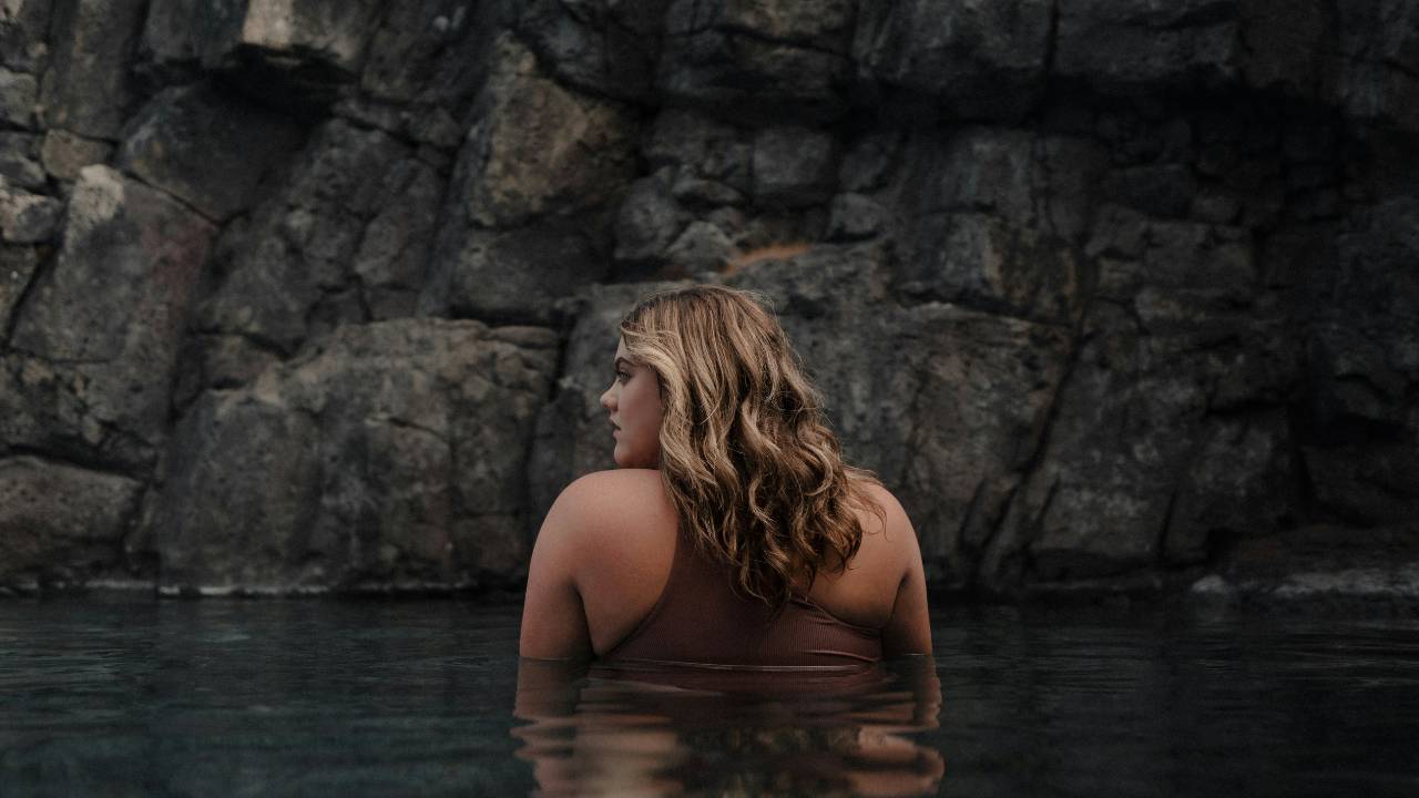a young woman relaxes in sky lagoon iceland