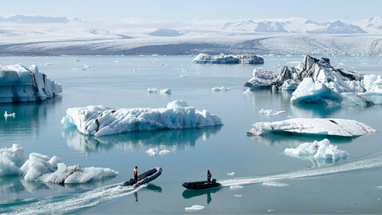 A couple of explorers sailing between Icelandic glaciers 