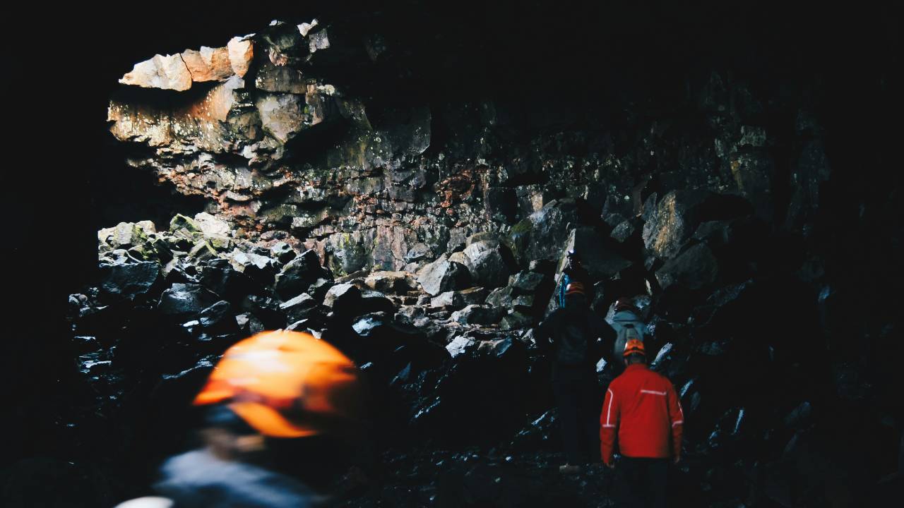 A couple of tourists exploring a lava tunnel in Iceland